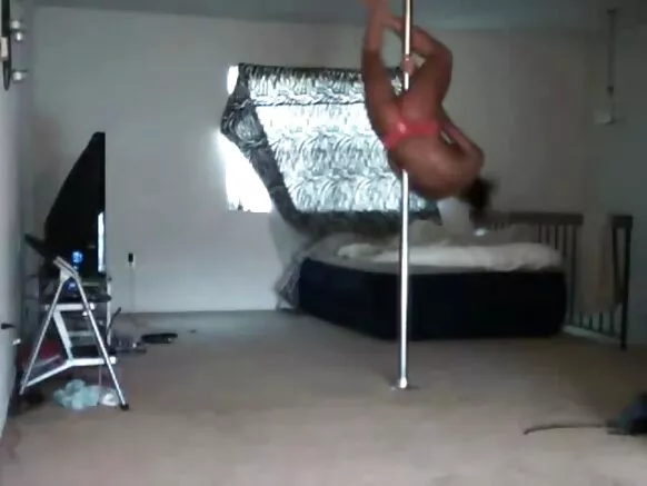 আবলুস কালো বিবিডব্লিউ একটি নাচে একটি খুঁটিতে চড়ে।